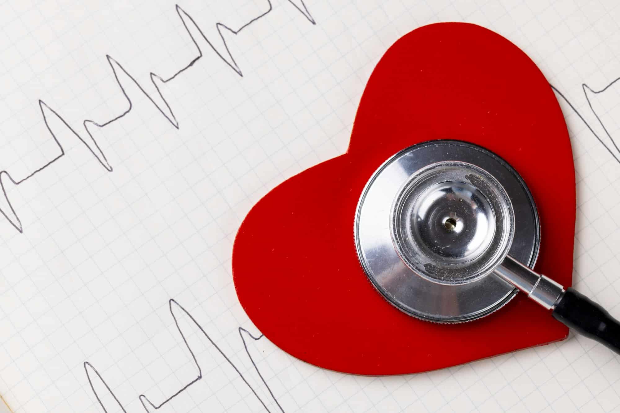 Image of red heart and stethoscope on white surface with heart rate