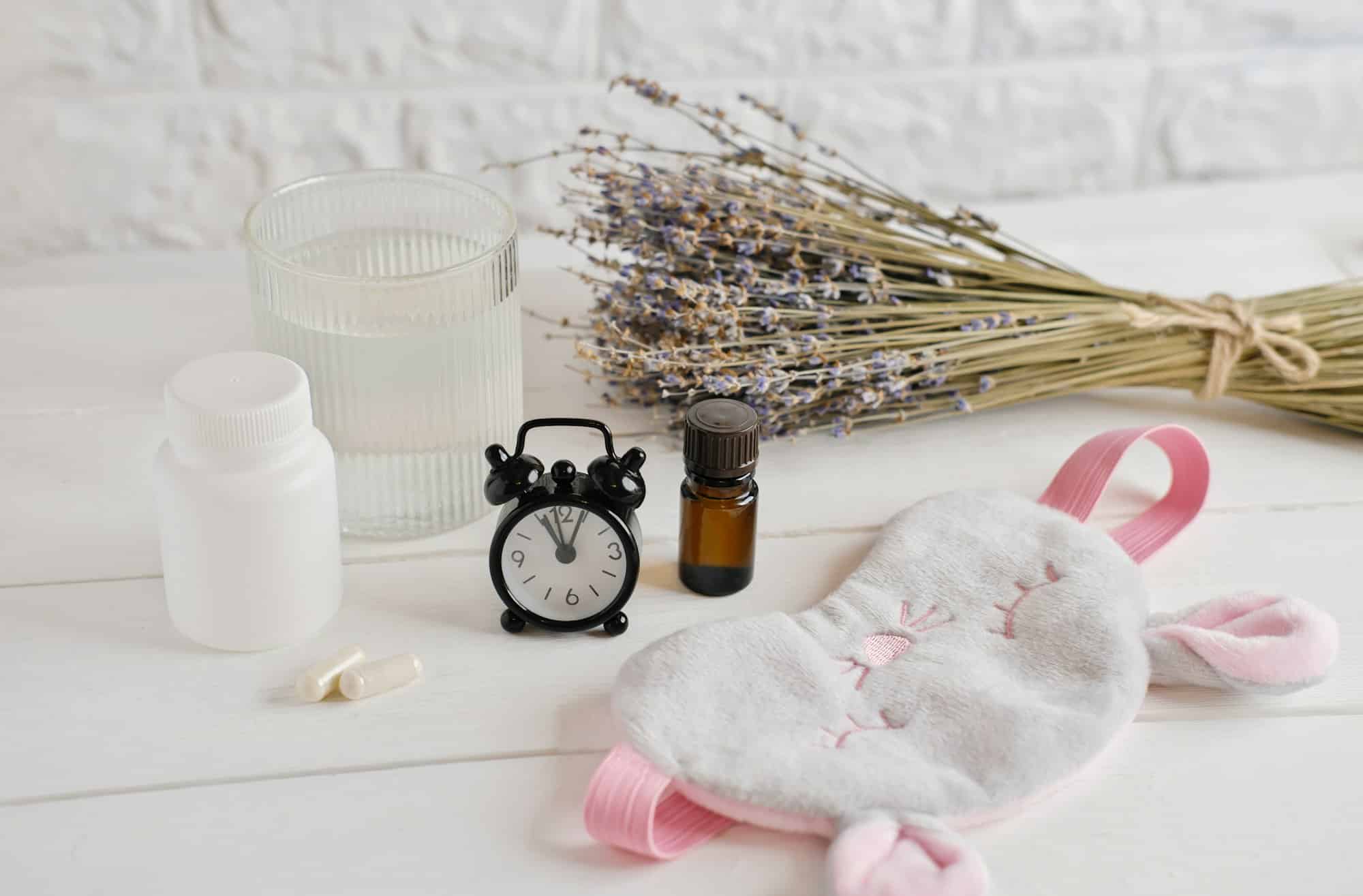 melatonin capsules and lavender essential oil on a table