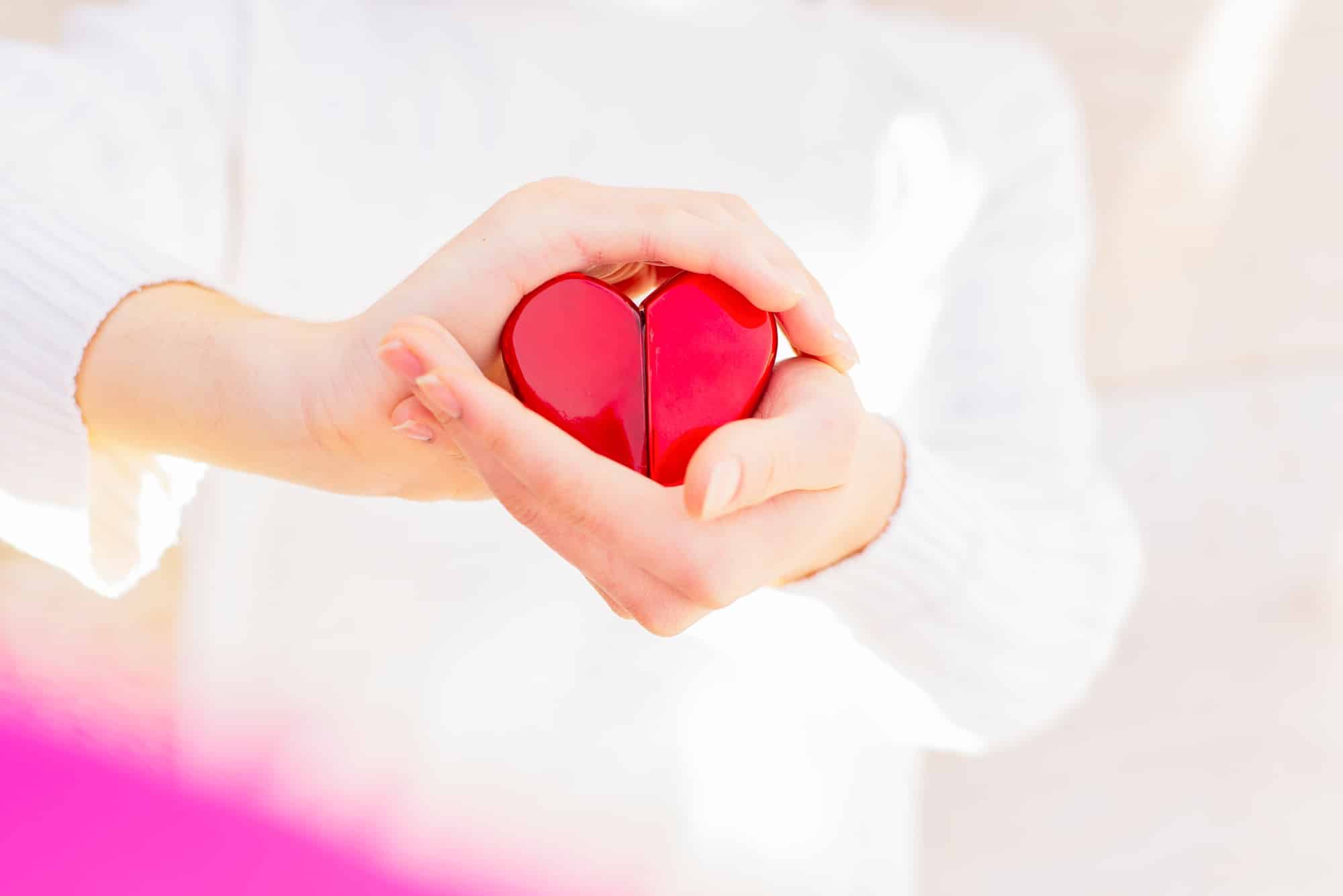 hands are holding a souvenir heart,a gesture of protection or care,the concept of maintaining health