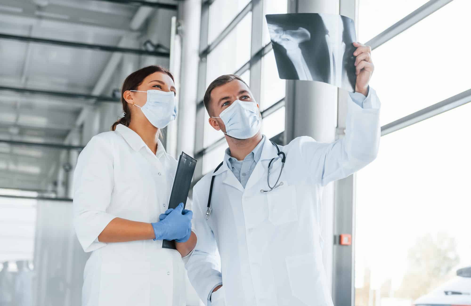 Having busy day. Two doctors in white coats is in the clinic working together