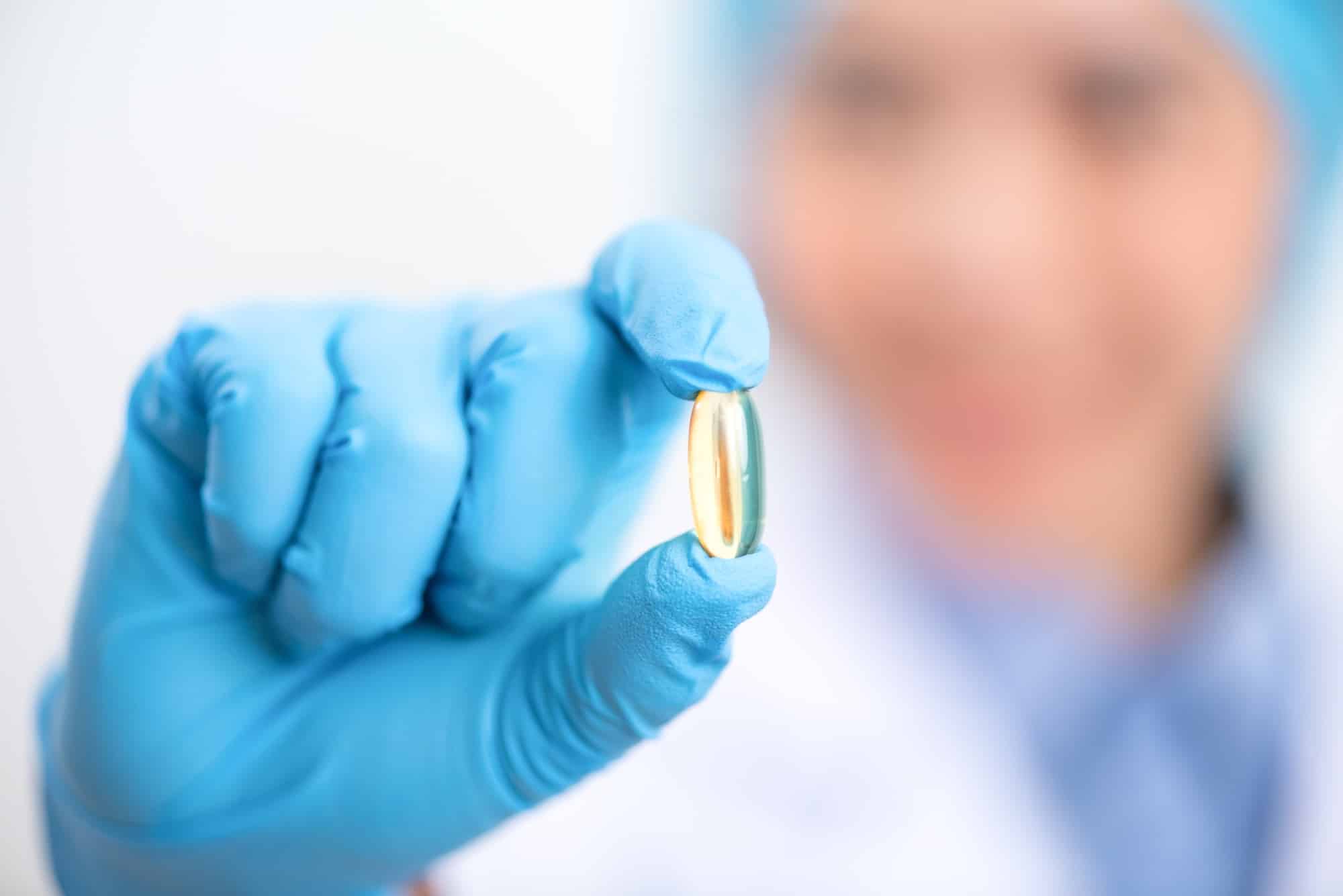 Fish oil capsules with omega 3 and vitamin D in a glass bottle